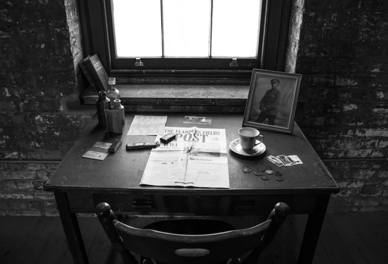 a black and white photo of a desk in front of a window, private press, on a rough wooden dungeon table, jack the ripper, old retro museum exhibition, photo taken with sony a7r