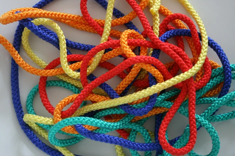 a pile of multicolored rope sitting on top of a white plate, by Brenda Chamberlain, closeup photo, colorful”, version 3, zippers