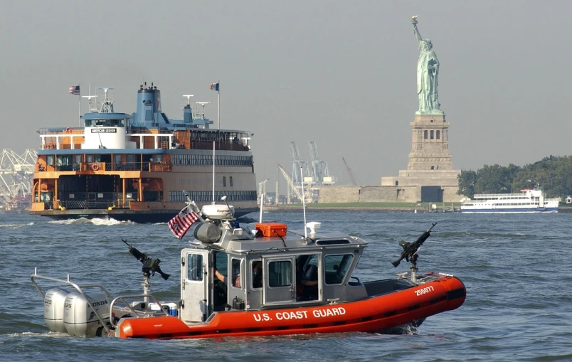 a boat in the water with a statue of liberty in the background, a picture, by Robert Medley, military police, emergency countermeasures, greg hildebrant, mid shot photo