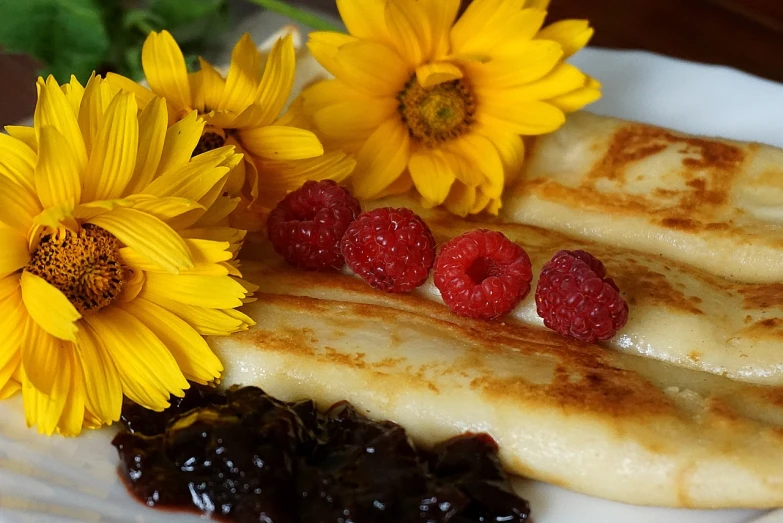 a white plate topped with pancakes and raspberries, a portrait, inspired by Maksimilijan Vanka, pixabay, with flowers and plants, silk, fan favorite, rectangular