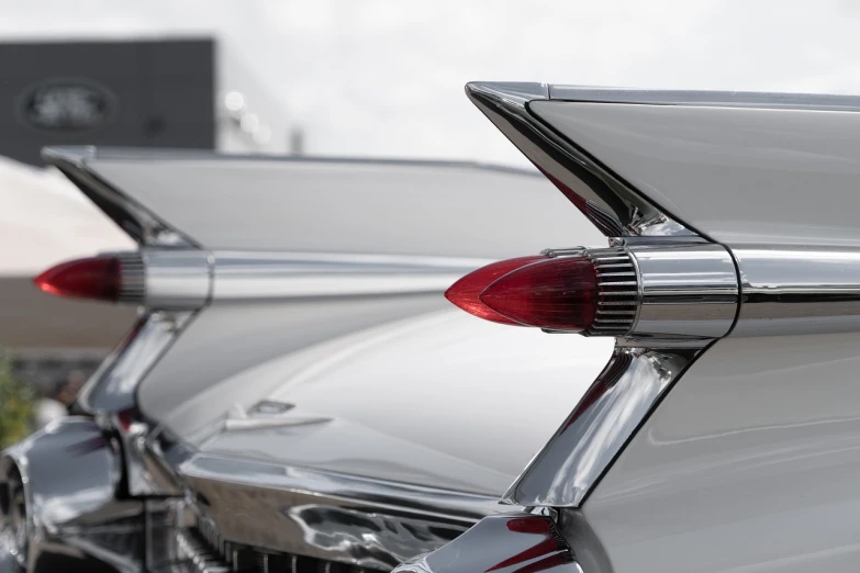 a row of classic cars parked next to each other, by Etienne Delessert, unsplash, modernism, silver white red details, tail fin, detail shot, spires