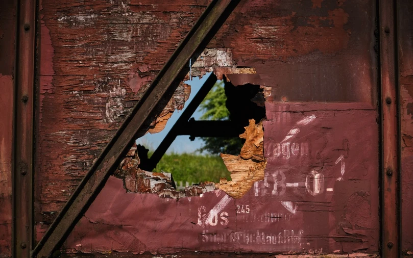 a hole in the side of a building with graffiti on it, inspired by William Harnett, flickr, train window, shot on canon eos r5, ripped up field fatigues, summer sun