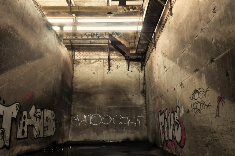 a dark room with graffiti on the walls, by Bascove, flickr, backrooms abandoned mall, sewer background, wet concrete, iso 500