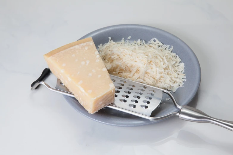 a piece of cheese and a grater on a plate, a picture, shutterstock, mingei, half body photo, rice, italian, florida