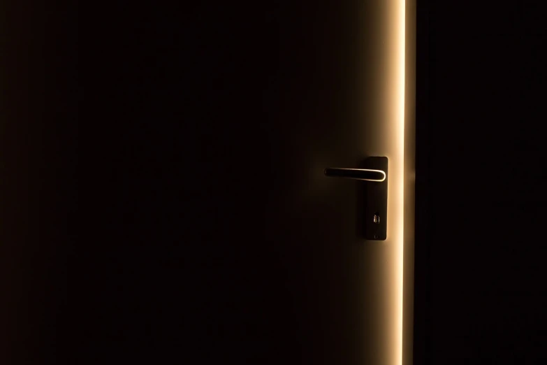 a close up of a door in a dark room, a stock photo, by Andrei Kolkoutine, light and space, warm illumination, minimalist lighting, nightlight, lock