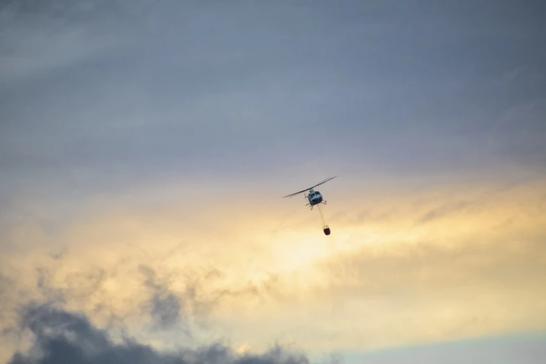 a helicopter that is flying in the sky, by Etienne Delessert, unsplash, hurufiyya, bushfire, summer evening, crane, idaho