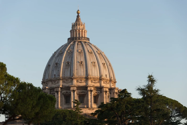 a dome on top of a building surrounded by trees, a picture, by Cagnaccio di San Pietro, shutterstock, evening light, pope, stock photo