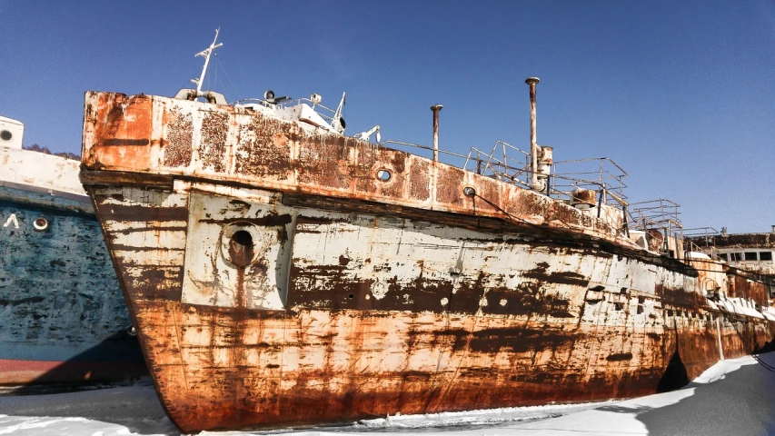 a couple of boats that are sitting in the snow, by Arthur Sarkissian, unsplash, romanticism, a photograph of a rusty, sea monster looks like ship, profile shot, heavy paint