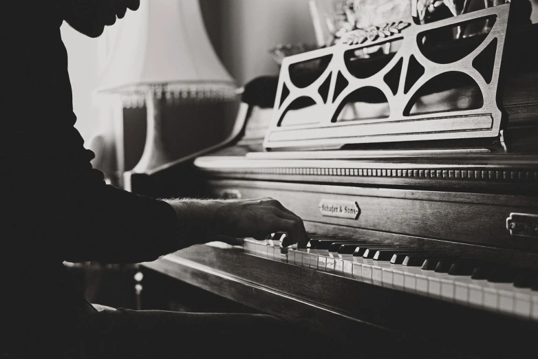 a black and white photo of a man playing a piano, unsplash, fine art, cozy atmospheric, shot on nikon d 3 2 0 0, photo pinterest, warm light