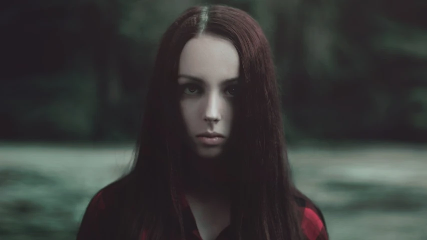 a close up of a person with long hair, inspired by Elsa Bleda, portrait of a ominous girl, symmetrical portrait, slightly red, serious focussed look