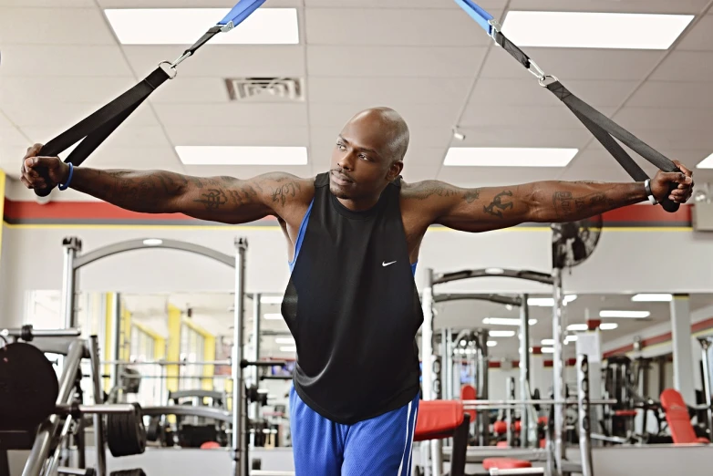 a man doing pull ups in a gym, a portrait, by Paul Davis, pexels, shaquille o'neil pregnant, black shirt with red suspenders, a bald, robotic extended arms