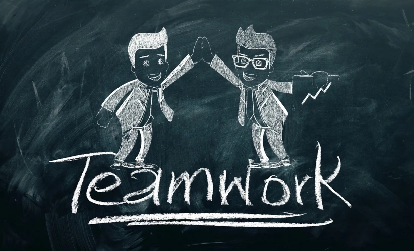 two men standing in front of a blackboard with the word teamwork written on it, a picture, by Caroline Mytinger, trending on pixabay, graffiti, istock, super - detailed work, people at work, chalk drawing