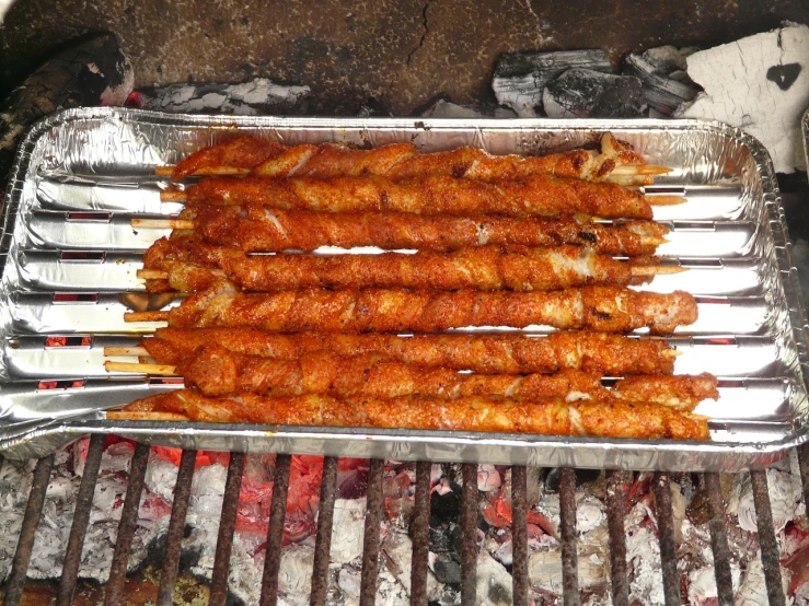 a close up of a tray of food on a grill, hurufiyya, long metal spikes, absolutely outstanding image, stacked, recipe