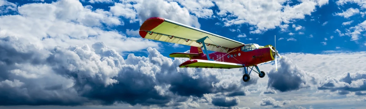 a red and yellow plane flying through a cloudy sky, a colorized photo, by Jan Rustem, pixabay contest winner, cessna glider plane, blue sky, v wing, summer sky