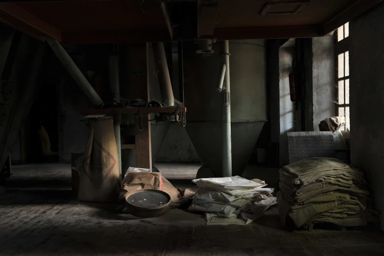 a pile of bags sitting on top of a wooden floor, a portrait, by Yasushi Sugiyama, flickr, shin hanga, abandoned factory, dark scene with dim light, powder, mill