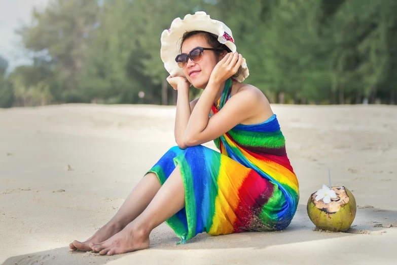 a woman sitting on a beach next to a coconut, a portrait, by Edward Corbett, shutterstock, rainbow clothes, beautiful asian woman sitting, full of colour 8-w 1024, with sunglass