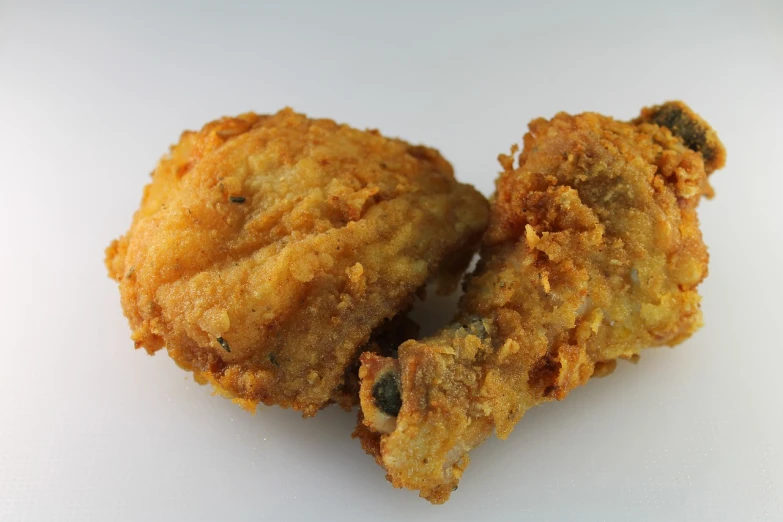 a couple of fried chicken sitting on top of a white table, by John Henderson, pixabay, hurufiyya, side view close up of a gaunt, high quality product image”, 3/4 view from below, ripley scott