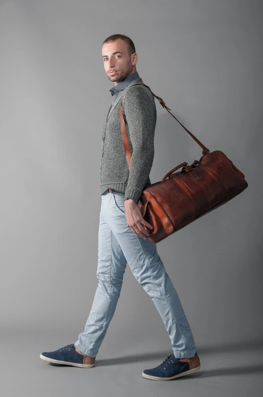 a man carrying a brown leather duffel bag, a picture, renaissance, full length photo, gray men, tocchini, monia merlo