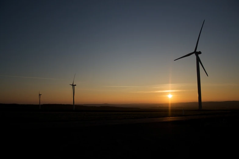 a group of wind turbines sitting on top of a field, a picture, by Thomas Häfner, silhouette over sunset, photo 85mm, night photo, ultrawide shot