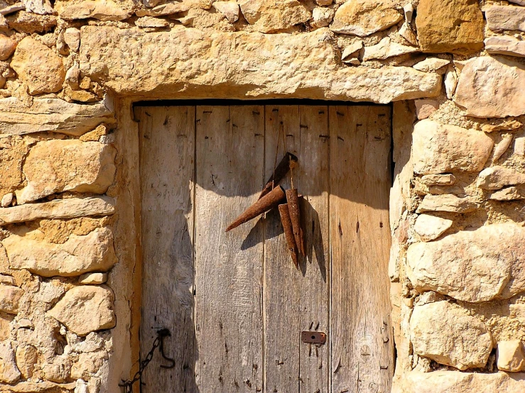 a close up of a door in a stone building, a photo, by Carlo Carrà, with a wooden stuff, pterodactyl, harvest, cyprus