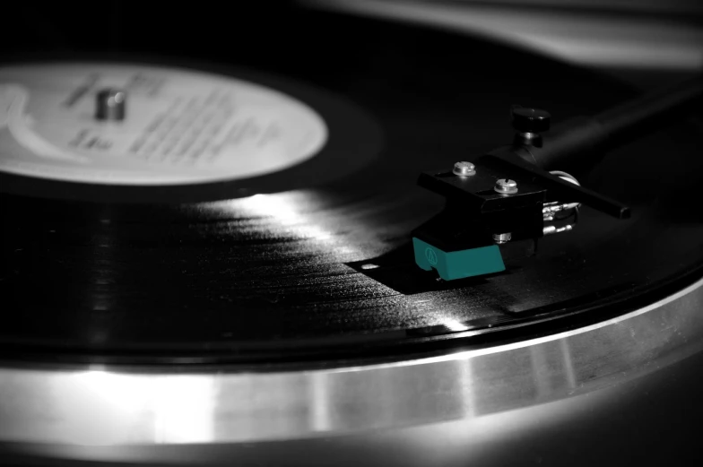 a black and white photo of a turntable, an album cover, unsplash, fine art, black and teal paper, close-up 35mm macro shot, jamming to music, vinyl cut ready