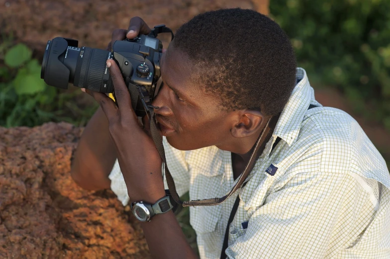 a man taking a picture with a camera, by Ingrida Kadaka, wildlife photograph, emmanuel shiru, many details, professional photograph