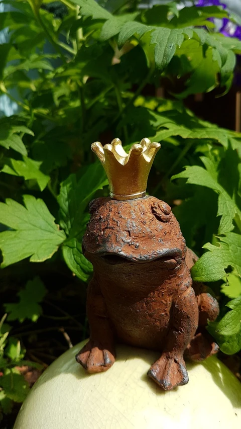 a statue of a frog with a crown on its head, by Edward Corbett, tiny firespitter, (((rusty))), golden crown, gardening