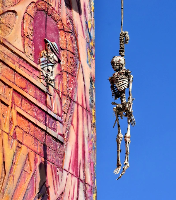 a skeleton hanging from the side of a building, inspired by Max Ernst, street art, super detailed image, details and vivid colors, 40k, puppet on a string