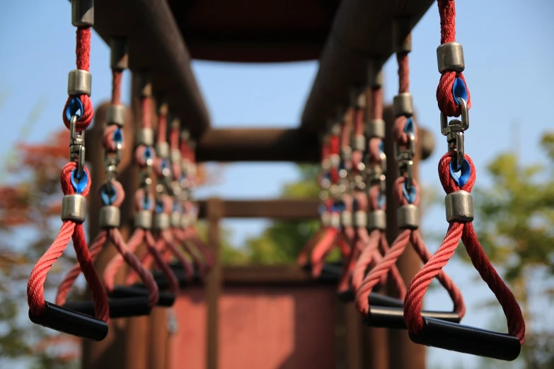 a close up of ropes attached to a wooden structure, a picture, by Torii Kiyomasu II, unsplash, playground, conveyor belts, looks realistic, at a park