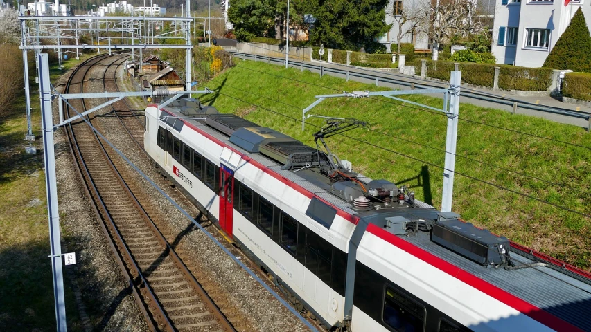 a large long train on a steel track, by Karl Stauffer-Bern, shutterstock, sunny day time, 🕹️ 😎 🚬, white and red color scheme, springtime morning