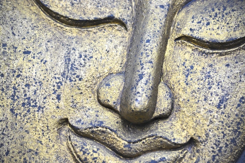 a close up of a statue of a person's face, concrete art, gold and indigo, buddhist, detailed smile, los angeles ca