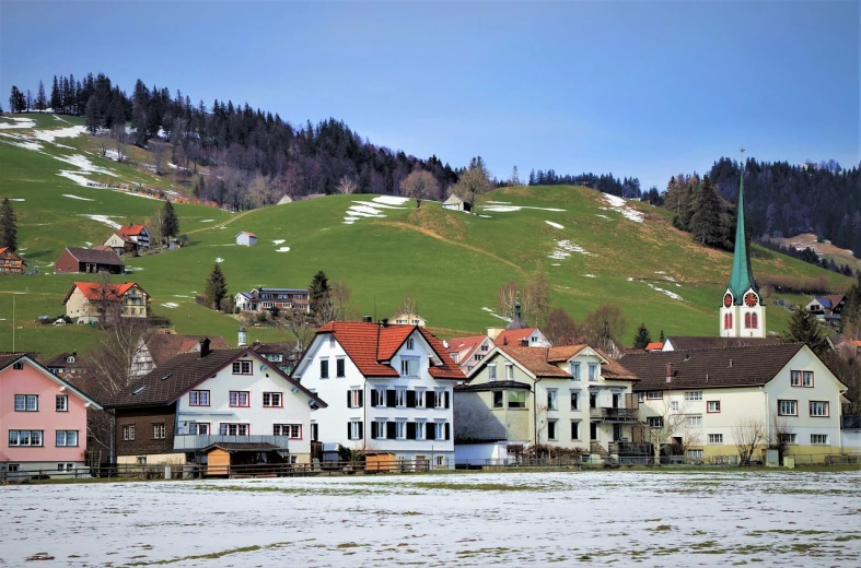 a group of houses sitting on top of a snow covered hillside, a portrait, inspired by Otto Meyer-Amden, flickr, springtime morning, photo taken in 2018, green meadows, beautiful small town