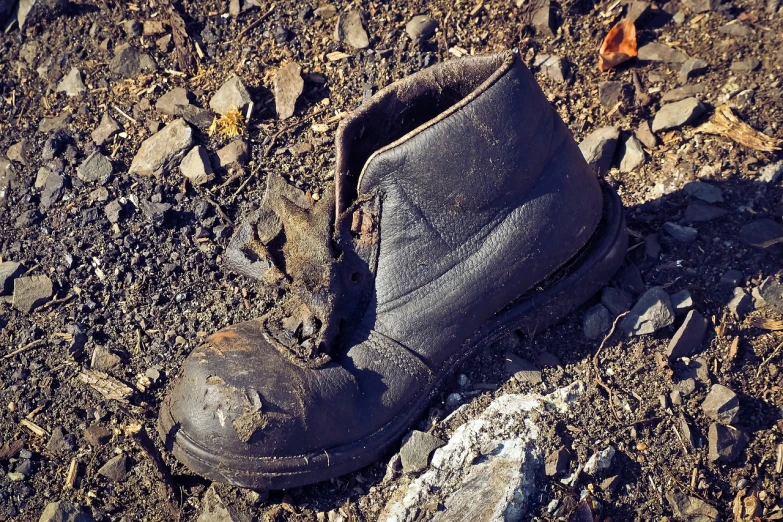 a close up of a dirty shoe on the ground, by Alexander Brook, shutterstock, destroyed armor, winter sun, slick!!, monitor