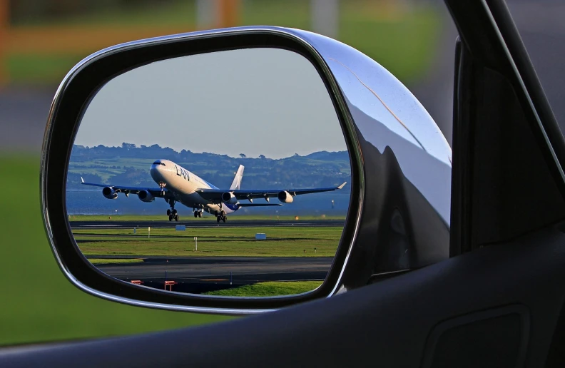 a large jetliner taking off from an airport runway, a picture, pixabay contest winner, photorealism, looking into a mirror, inside of a car, telephoto vacation picture, view from behind mirror