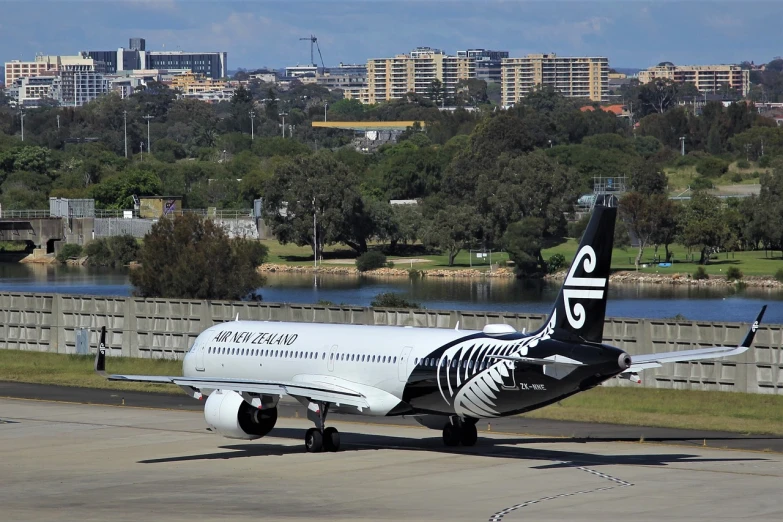 a large jetliner sitting on top of an airport runway, a picture, by Alexander Robertson, hurufiyya, maori, dazzle camouflage!!, photo taken in 2018, sydney