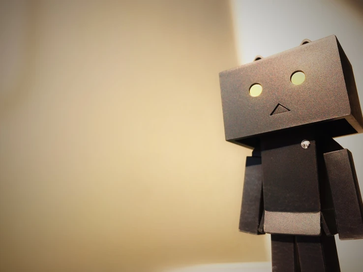 a toy made to look like a robot, a picture, inspired by Jean Tabaud, unsplash, cardboard, shadowy, blank expression, oversaturated