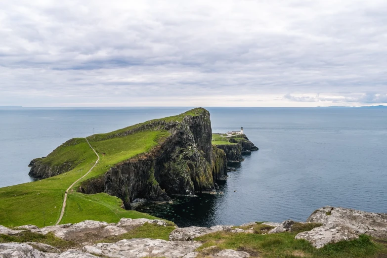 a small island in the middle of a large body of water, by John Murdoch, pexels contest winner, happening, scottish style, ocean cliff view, thors hammer, wikimedia commons