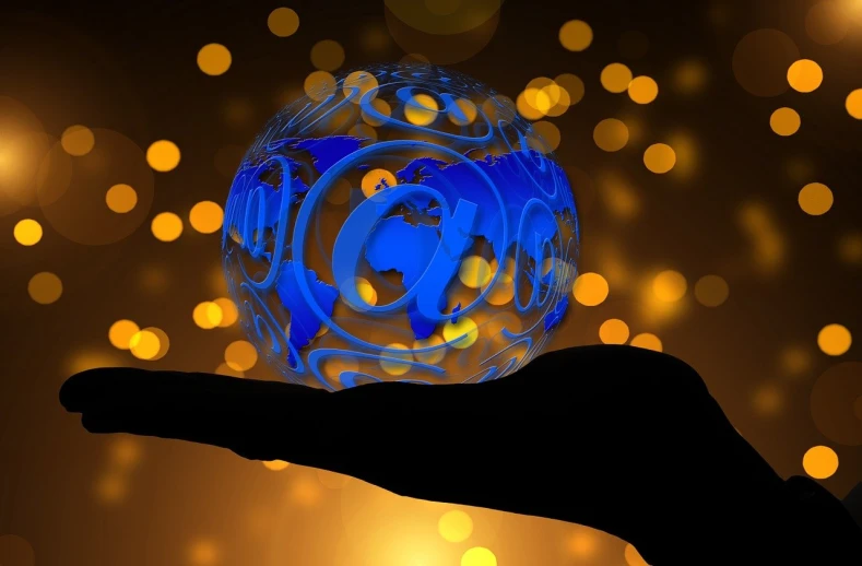 a person holding a glowing orb in their hand, a digital rendering, by Tom Carapic, pixabay, blue gold and black, in front of the internet, email, stylized silhouette