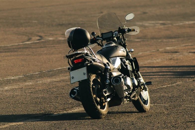 a motorcycle parked on the side of a dirt road, a picture, shutterstock, half rear lighting, backlight photo sample, swift, yoshimura exhaust