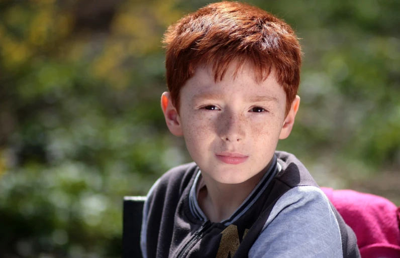 a close up of a child with a backpack, a picture, inspired by Robert Childress, pixabay contest winner, realism, red haired teen boy, acting headshot, on a sunny day, short red hair