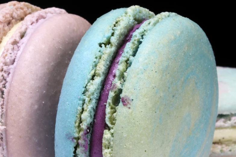 a couple of macarons sitting next to each other, flickr, art nouveau, extreme closeup shot, ultraviolet, powder, highly detailed close up