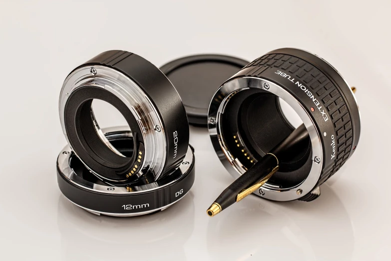 a couple of camera lenses sitting on top of each other, a macro photograph, by Aleksander Kotsis, photorealism, full frame mirrorless sensor, dorian cleavanger, turned back to camera, technological rings