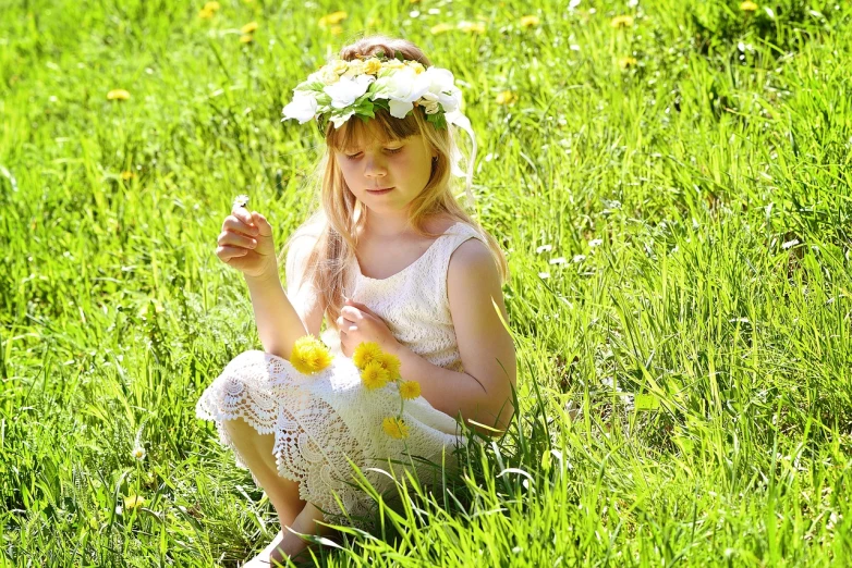 a little girl sitting in the grass with a flower crown on her head, a picture, inspired by Kate Greenaway, pixabay, romanticism, beautifully bright white, goddess of spring, blond, girl with feathers