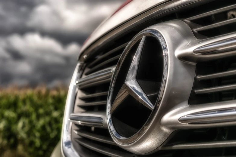a close up of a mercedes logo on a car, a picture, by Thomas Häfner, pexels, photorealism, intense dramatic hdr, stock photo, metal body, ultrawide lens”