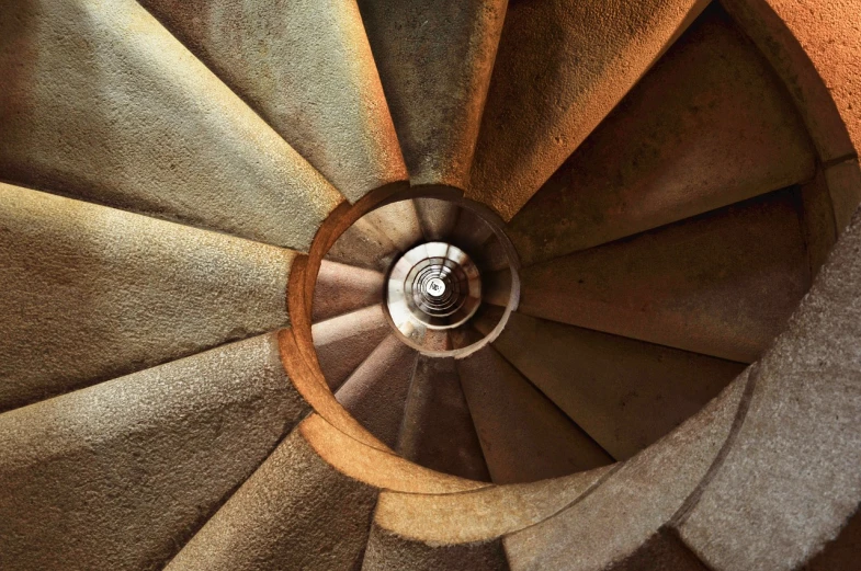 a spiral staircase leading to the top of a building, a picture, inspired by Rodolfo Escalera, pexels, deep crevices of stone, in barcelona, floating spiral sand, cone