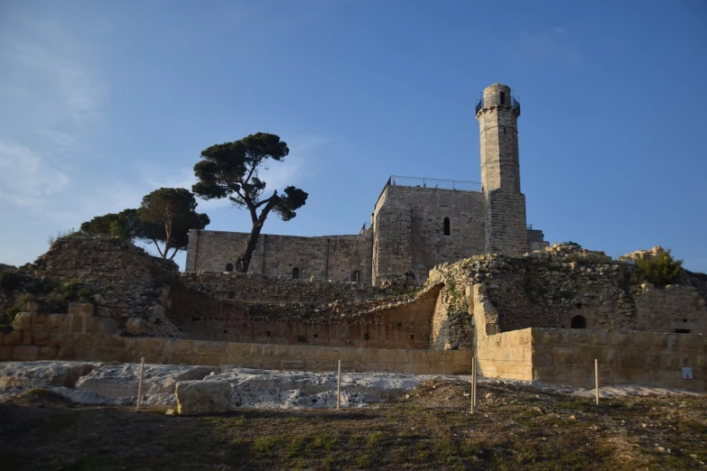 a tall tower sitting on top of a lush green hillside, les nabis, city ruins in the background, winter sun, front and side view, conversano