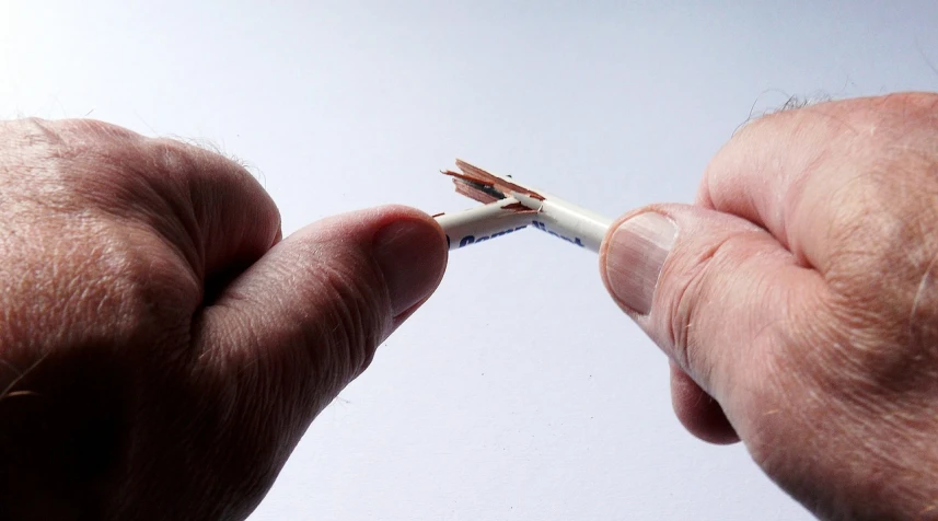 a close up of a person holding a toothbrush, a picture, by David Simpson, happening, broken wires, wikimedia, miniature photography closeup, holding pencil