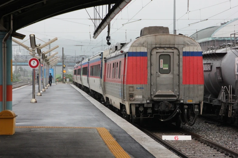 a train pulling into a train station next to a platform, a picture, flickr, greek romanian, nice slight overcast weather, img _ 9 7 5. raw, tgv