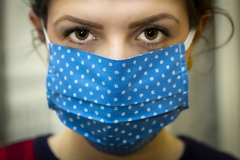 a close up of a person wearing a face mask, a picture, dressed in blue, looking at you, female looking, low resolution