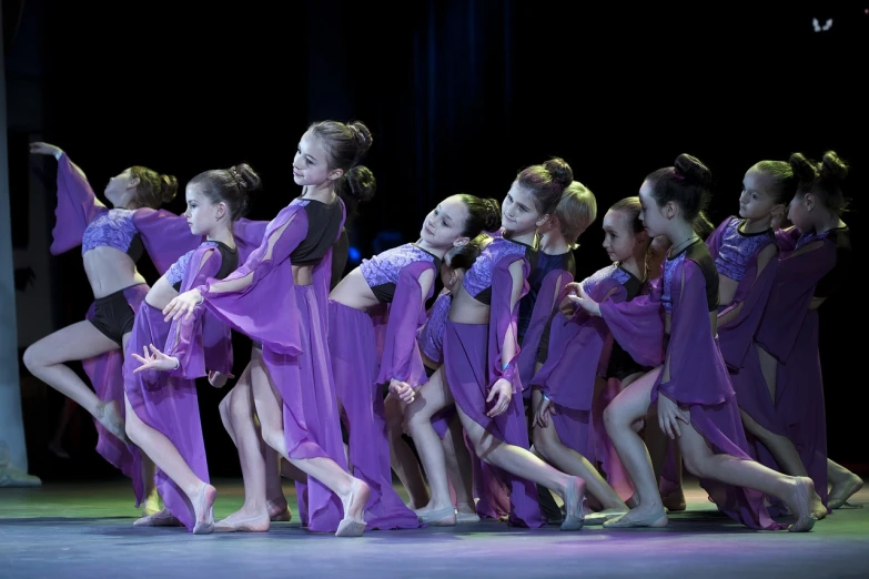 a group of young girls dancing on a stage, shutterstock, arabesque, purple clothes, photo taken on a nikon, side - view, vsevolod ivanov